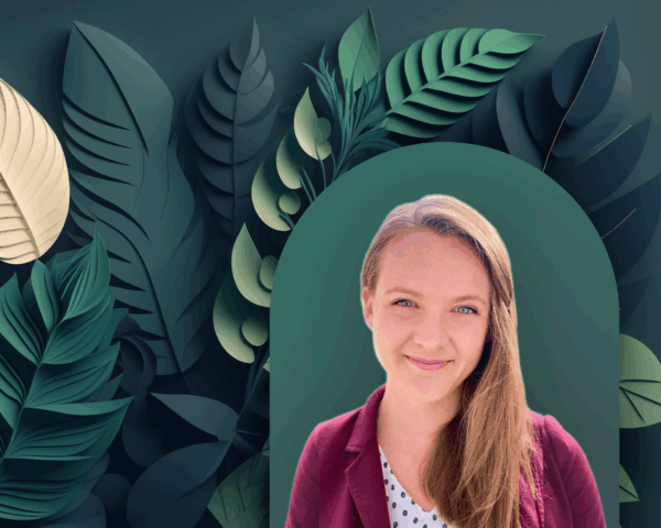 A woman with long light brown hair, wearing a maroon blazer and white polka-dot top, smiles in front of a leafy, dark green illustrated background with layered tropical leaves and subtle contract AI graphics.