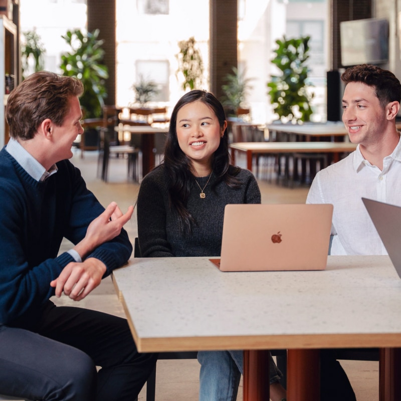 3 people around a laptop