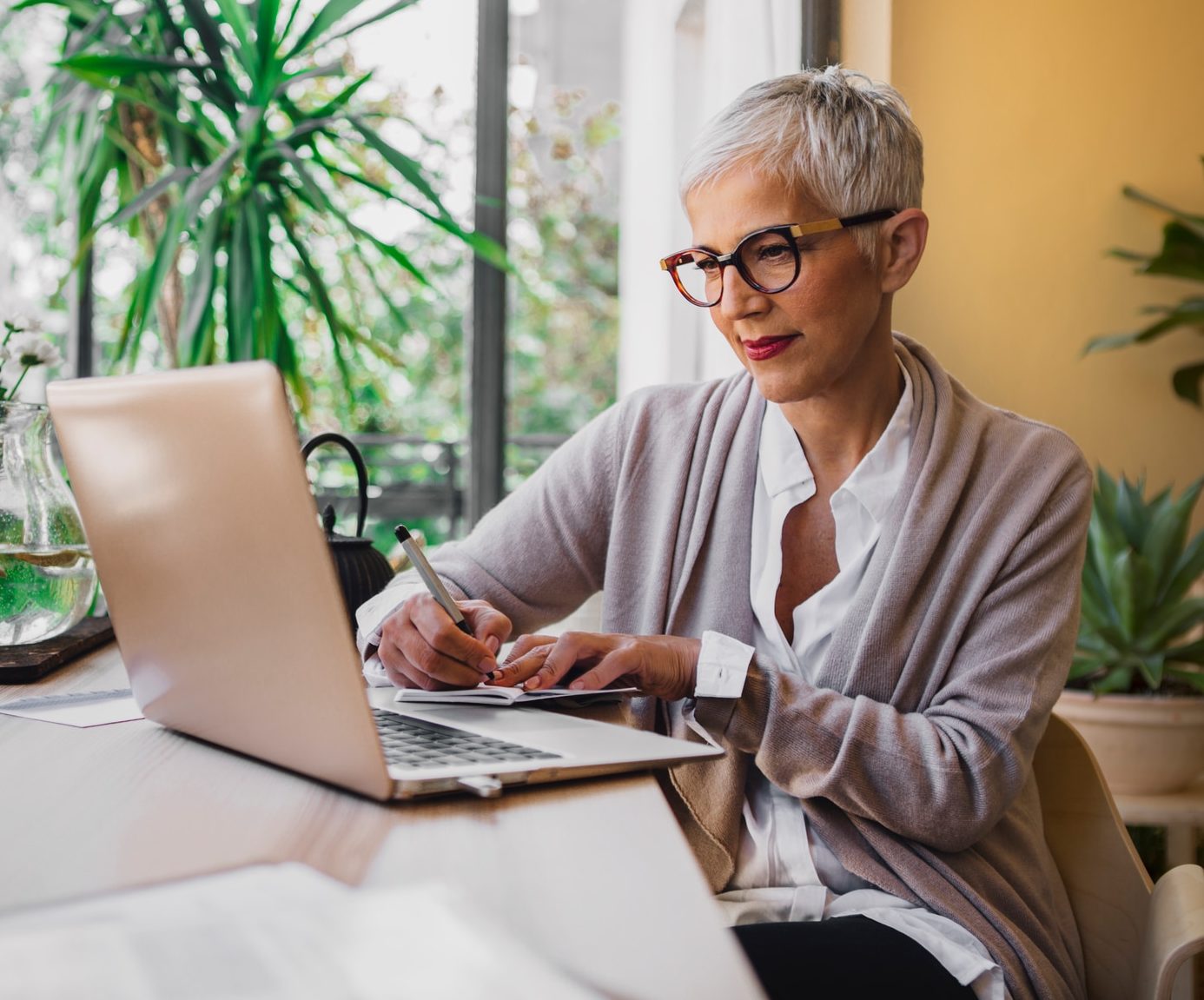 Woman sitting at her desk and writing in her notebook.