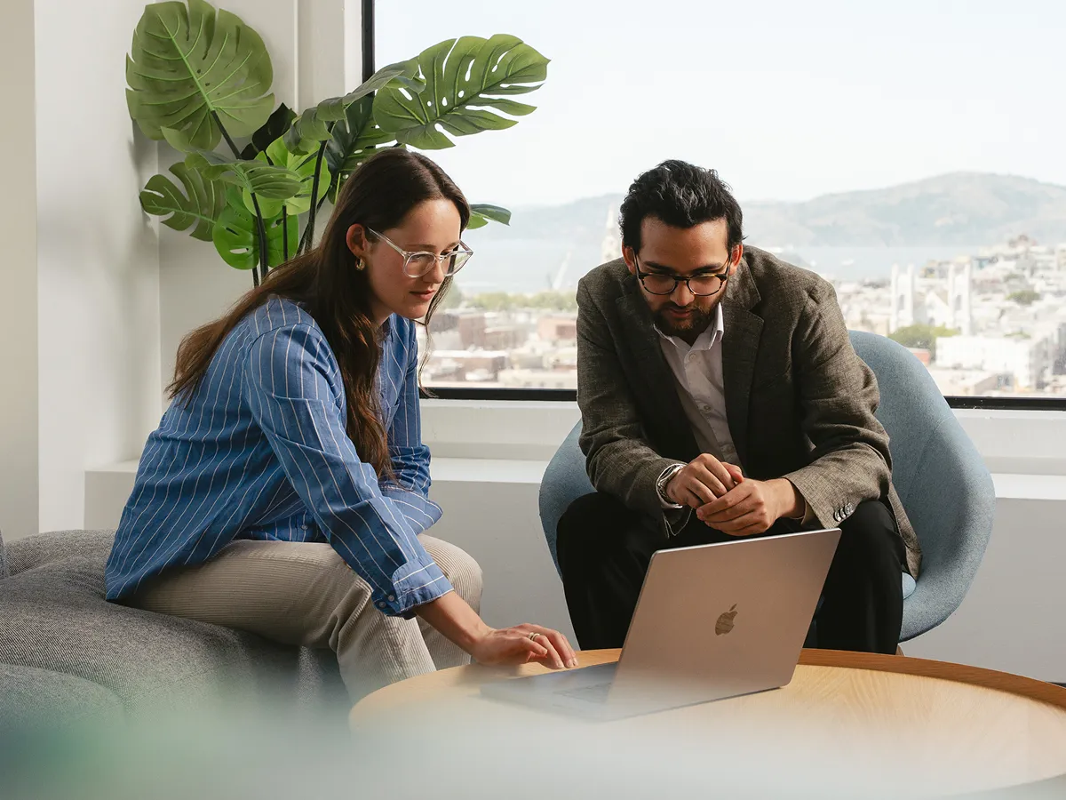 Chat with Peers and Experts two people looking at laptop