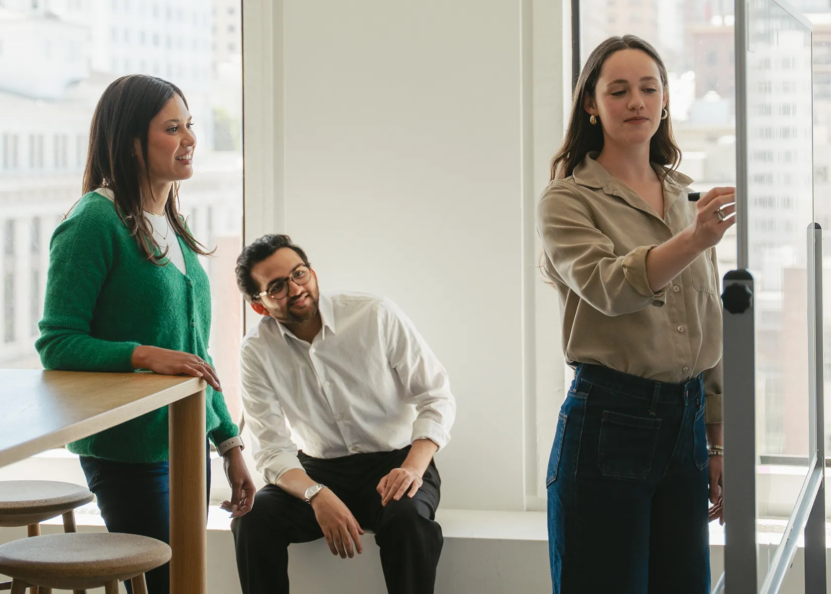 3 people working at a whiteboard