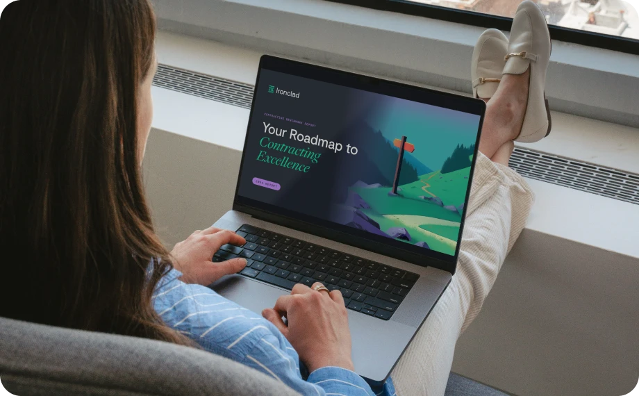 A person sits by a window with crossed legs, using a laptop that displays a website titled Your Roadmap to Contracting Excellence with an illustration of a signpost on a winding path.