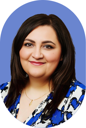 A woman with straight dark hair, wearing a blue and white patterned top and a gold necklace, smiles confidently in front of a solid blue background, embodying the professionalism often seen in contract intelligence.