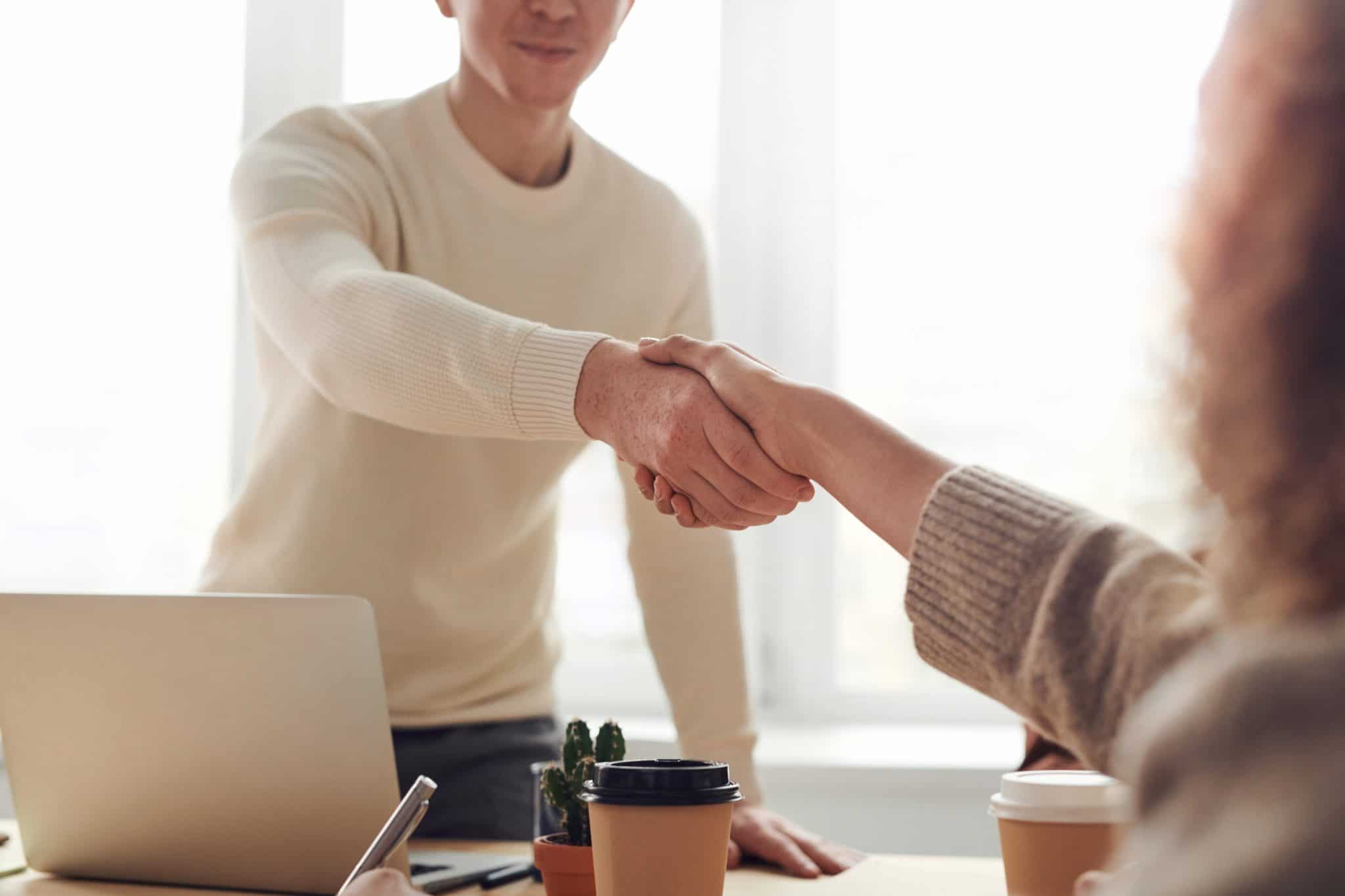 two persons shaking hands after contract review