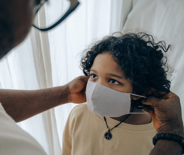 healthcare provider placing mask on young patient