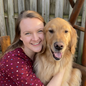 picture of becky holding her golden retriever and smiling