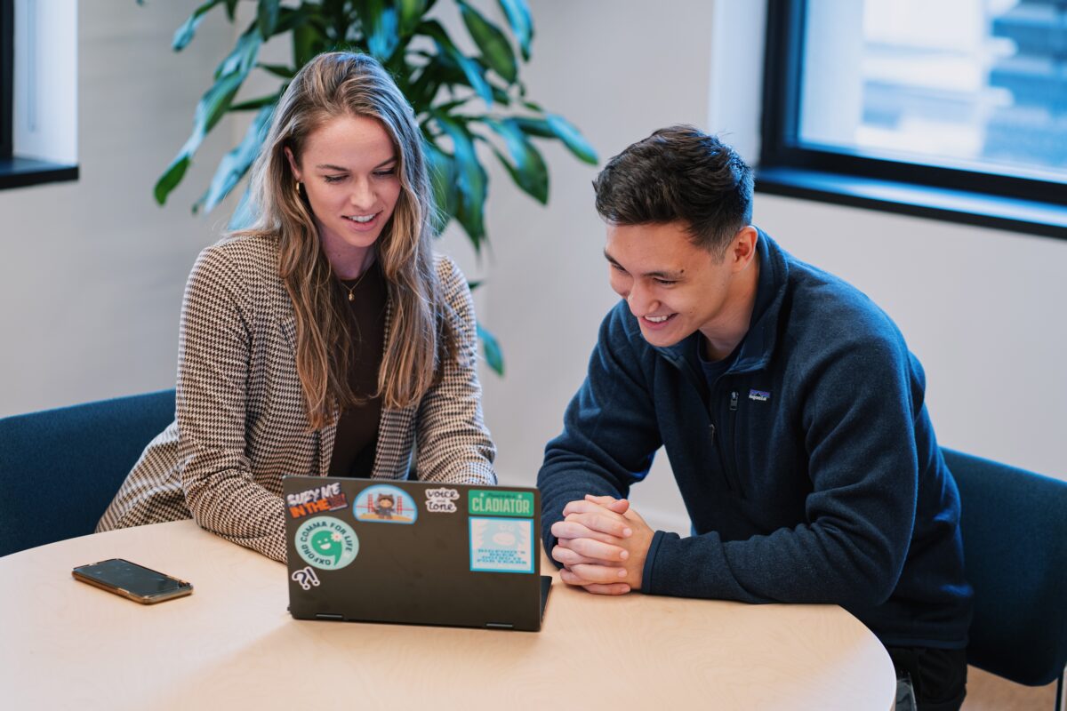 Two people in an office on a laptop