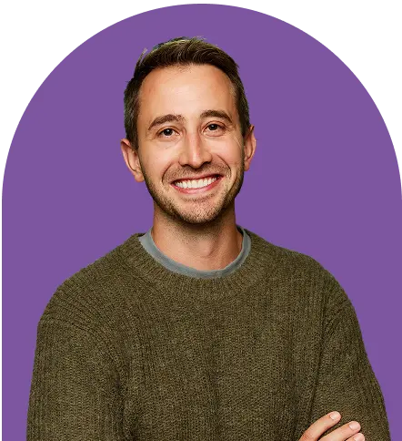 A smiling man with short brown hair, wearing a brown sweater, stands with his arms crossed in front of a solid purple background, exuding confidence like an ironclad CLM professional.
