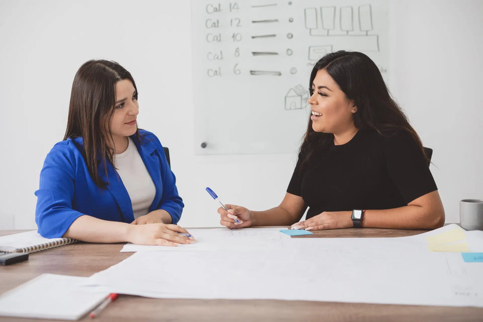 Two women discussing renewals and upsells contract