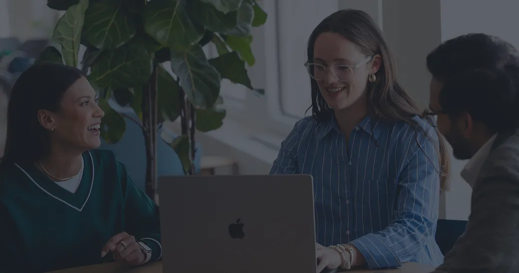3 people working around a laptop