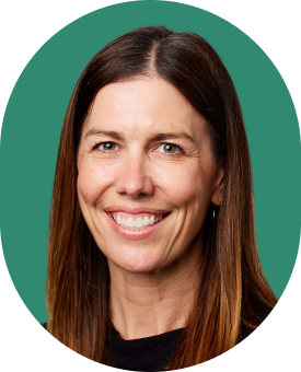 A woman with straight brown hair, smiling, wearing a black top. The background is green and the photo has rounded edges.