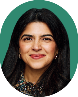A woman with long dark hair, wearing hoop earrings and a patterned top, smiling in front of a green background.