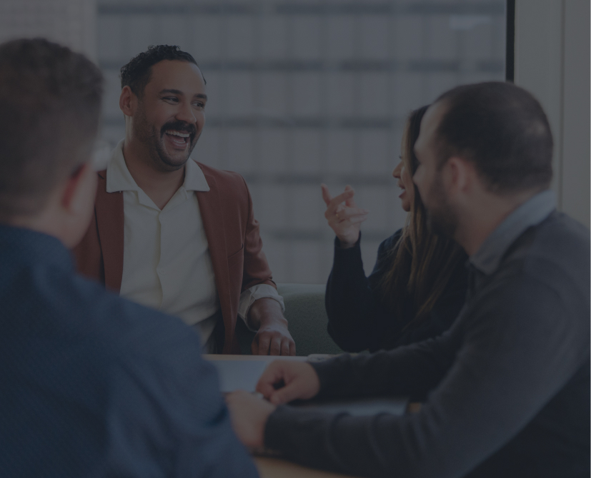 4 people sitting at a table laughing