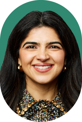 A woman with long dark hair, wearing gold hoop earrings and a multicolored textured top, smiles at the camera against a green background, embodying the confidence of an ironclad jurist AI.