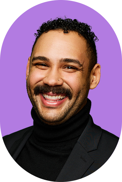 A smiling person with short curly hair, a mustache, and a nose piercing wearing a black turtleneck and blazer, posed in front of a purple background that evokes the innovative spirit of AI.